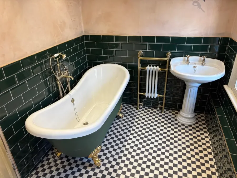 A roll-top bath and chequerboard floor fitted by TF Fitting & Installation