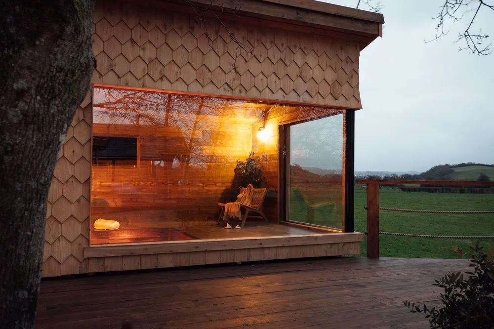 A With Bear Hands cabin glowing at dusk